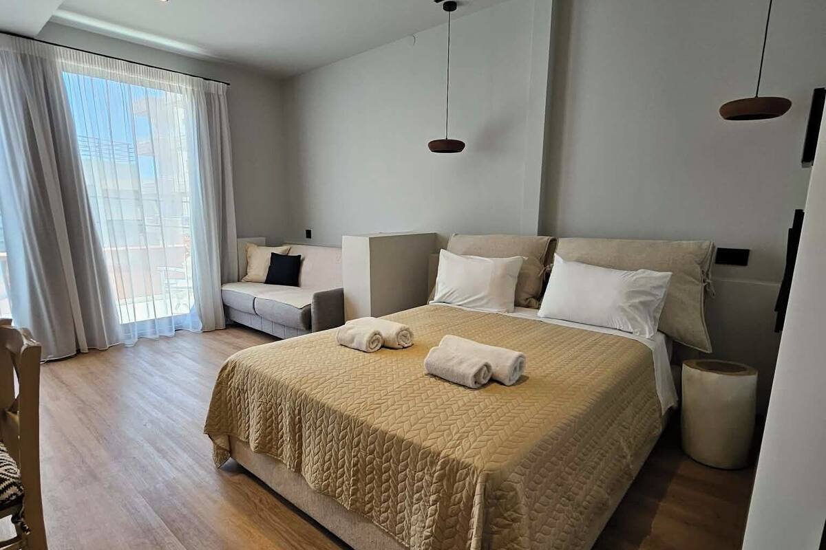 Une chambre à coucher moderne avec un grand lit, un bureau et une chaise.