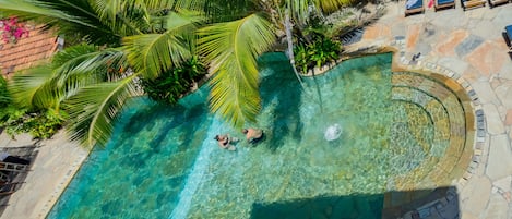 Una piscina al aire libre, sombrillas, tumbonas