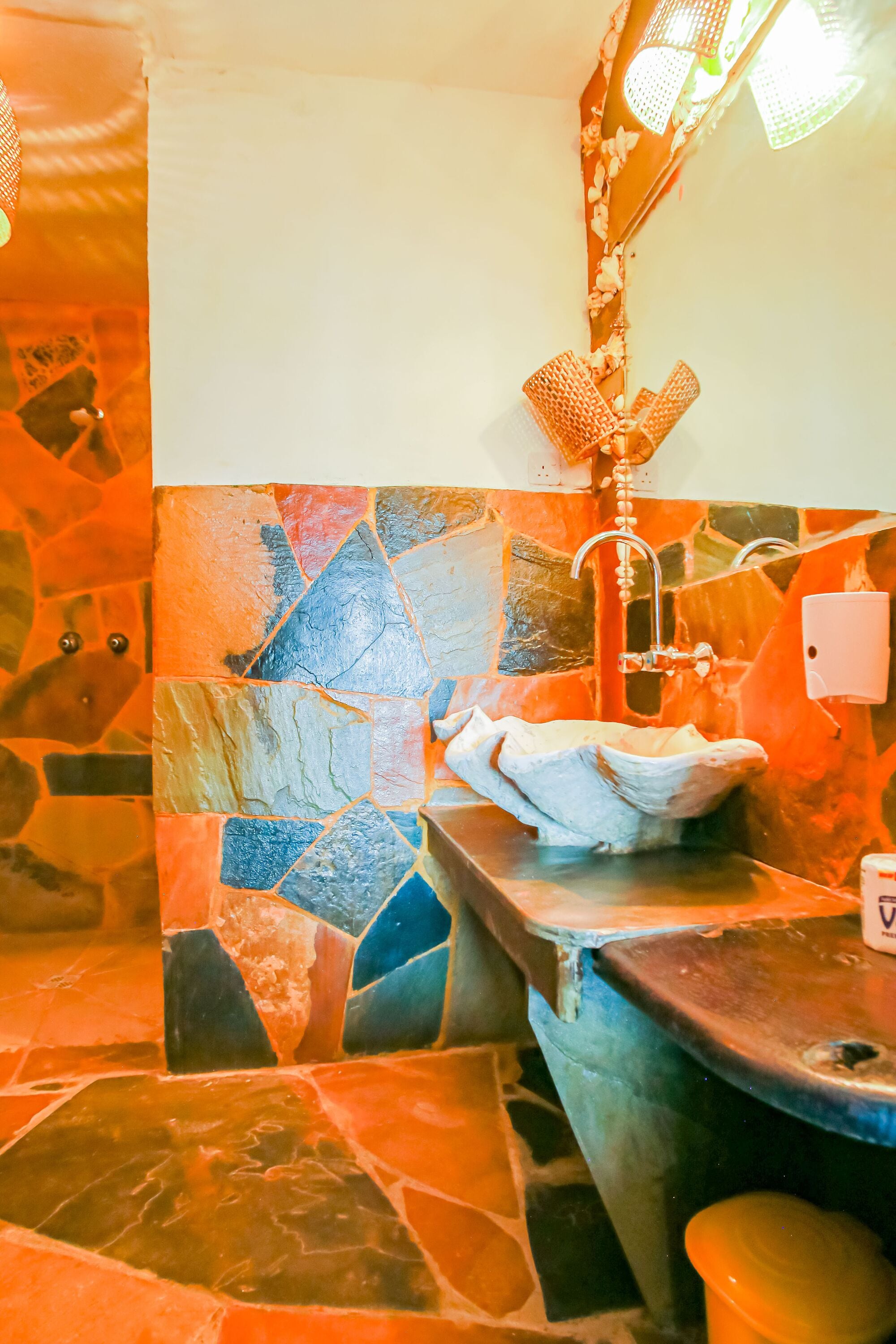 Un baño con pared de mosaicos, un lavamanos y un espejo.
