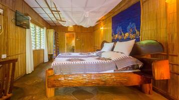 A wooden room with a bed, a window, and a tapestry on the wall.