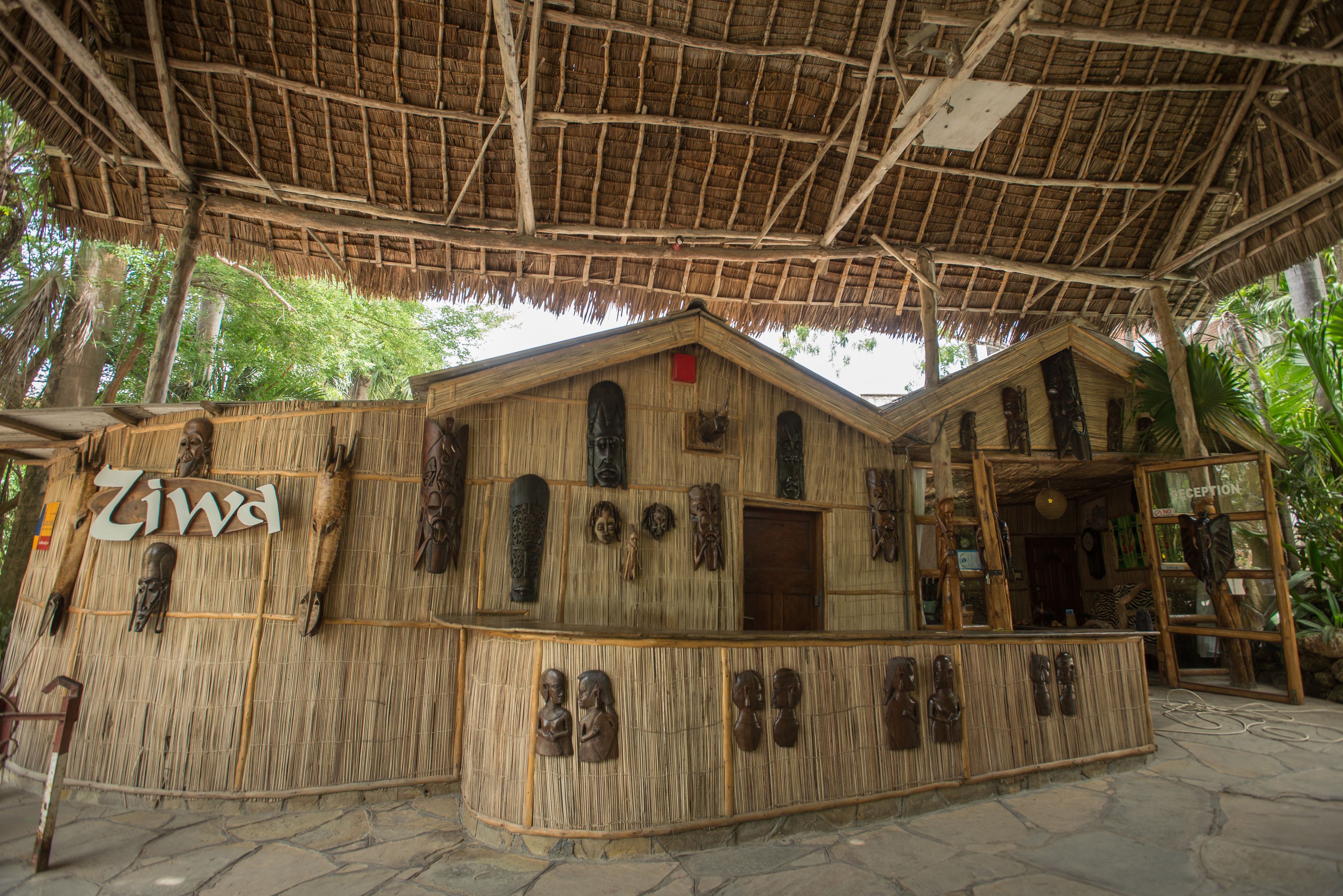 A rustic building with a thatched roof and wooden walls, labeled "Ziwa."