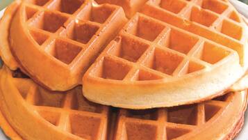 Un gros plan d’une gaufre à la croûte dorée et à la surface quadrillée.