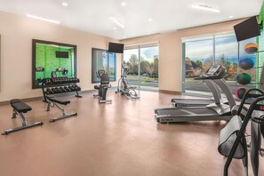 A gym with treadmills, a stationary bike, and dumbbells. - La Quinta Inn & Suites by Wyndham Cleveland near Lee Univ (Cleveland)