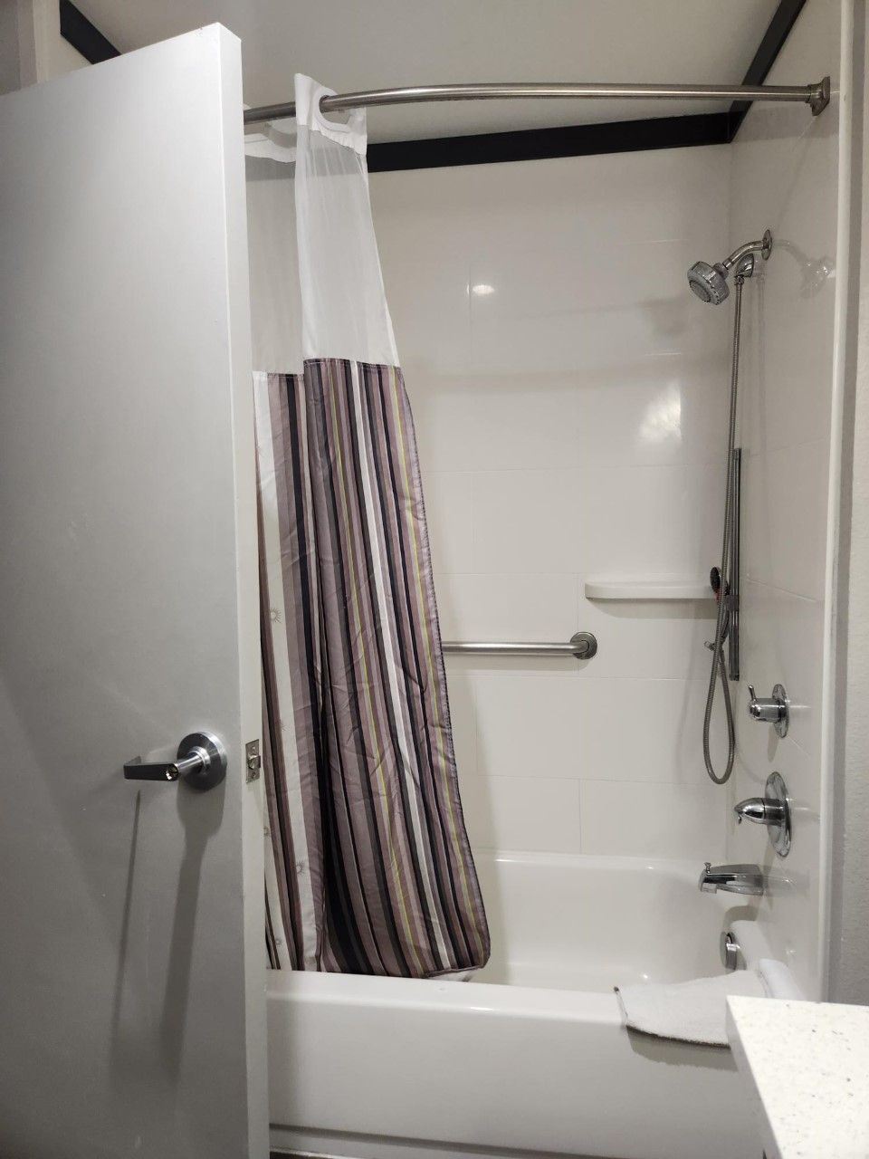 Un bagno con doccia, asciugamano e water.