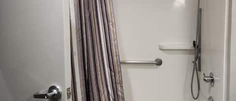 Un bagno con doccia, asciugamano e water.