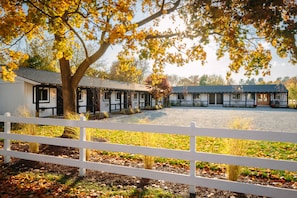 A traditional building with a large open courtyard, surrounded by a white fence. - Brentwood Hotel (Saratoga Springs)