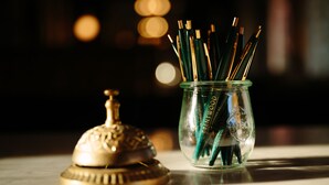Un bocal en verre rempli d’instruments d’écriture et doté d’un couvercle décoratif.