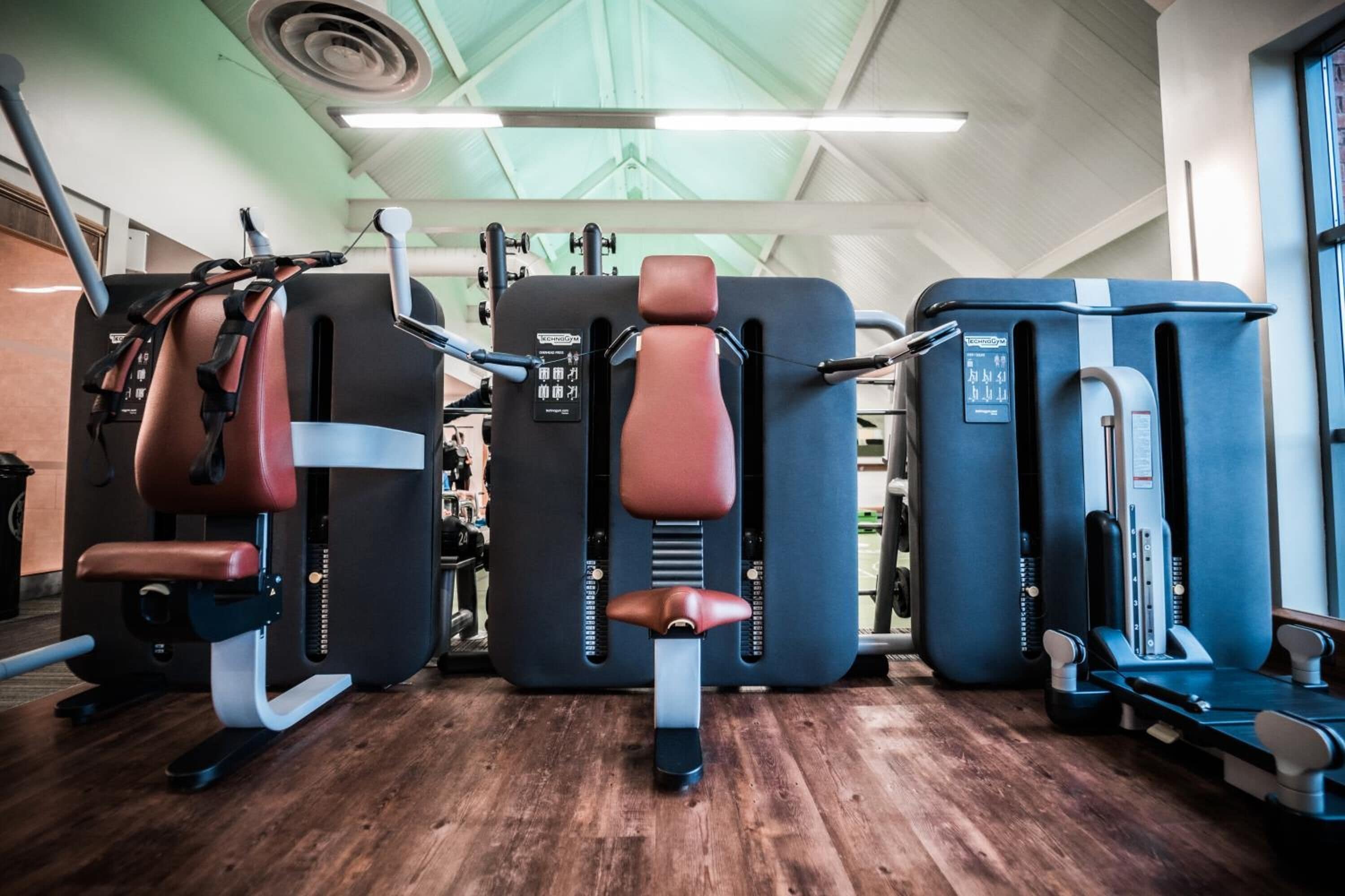 A gym with various exercise machines, including a leg press and a chest press.
