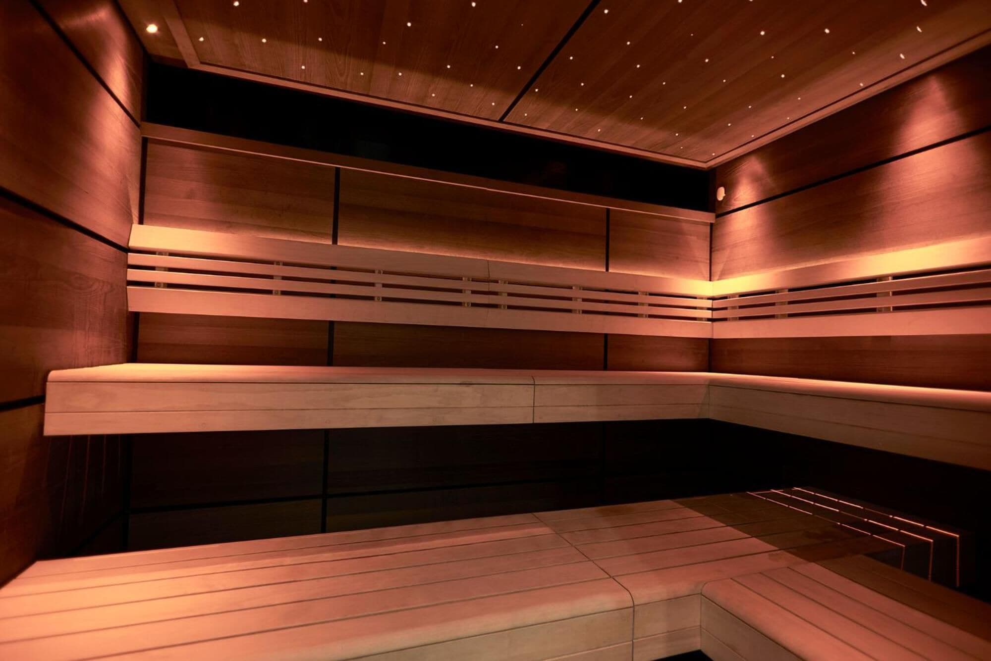 A modern sauna with wooden benches and a sloped ceiling.