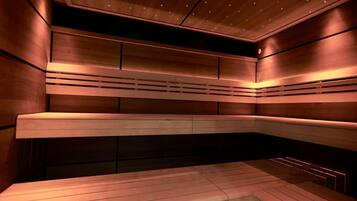 Una sauna moderna con bancos de madera y techo inclinado.