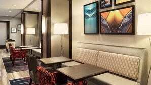A hotel lobby with seating areas, tables, and artwork on the walls.