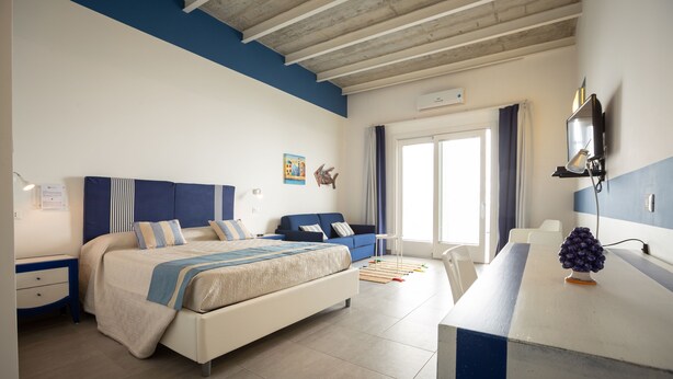 Ein Schlafzimmer mit Bett, Schreibtisch, Stuhl und Fenster.