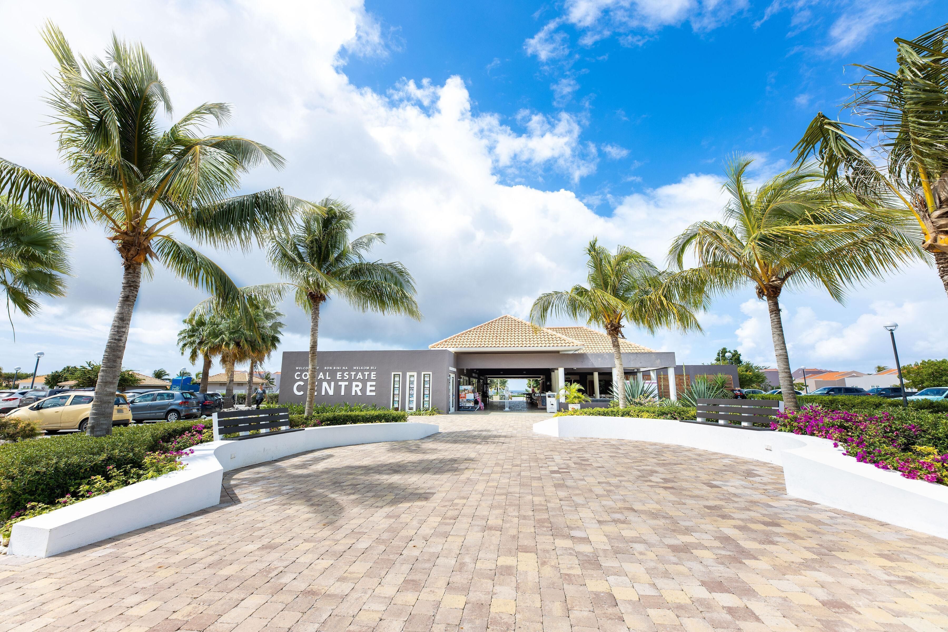 A modern building with a tiled roof and a paved entrance area.