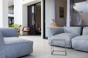A modern living room with a grey sectional sofa, a small table, and a wicker basket.