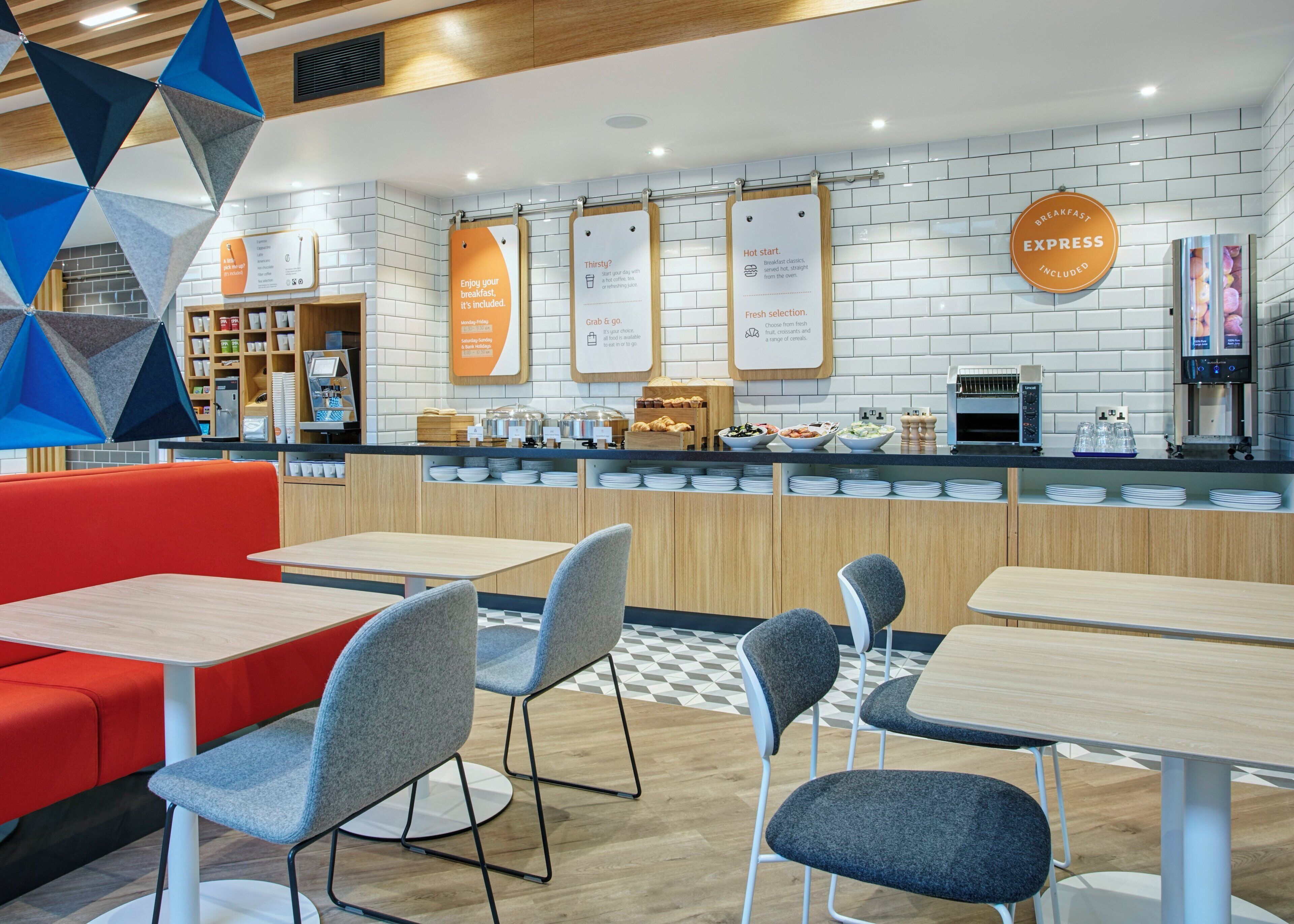 A modern breakfast area with a counter, seating, and a menu board.