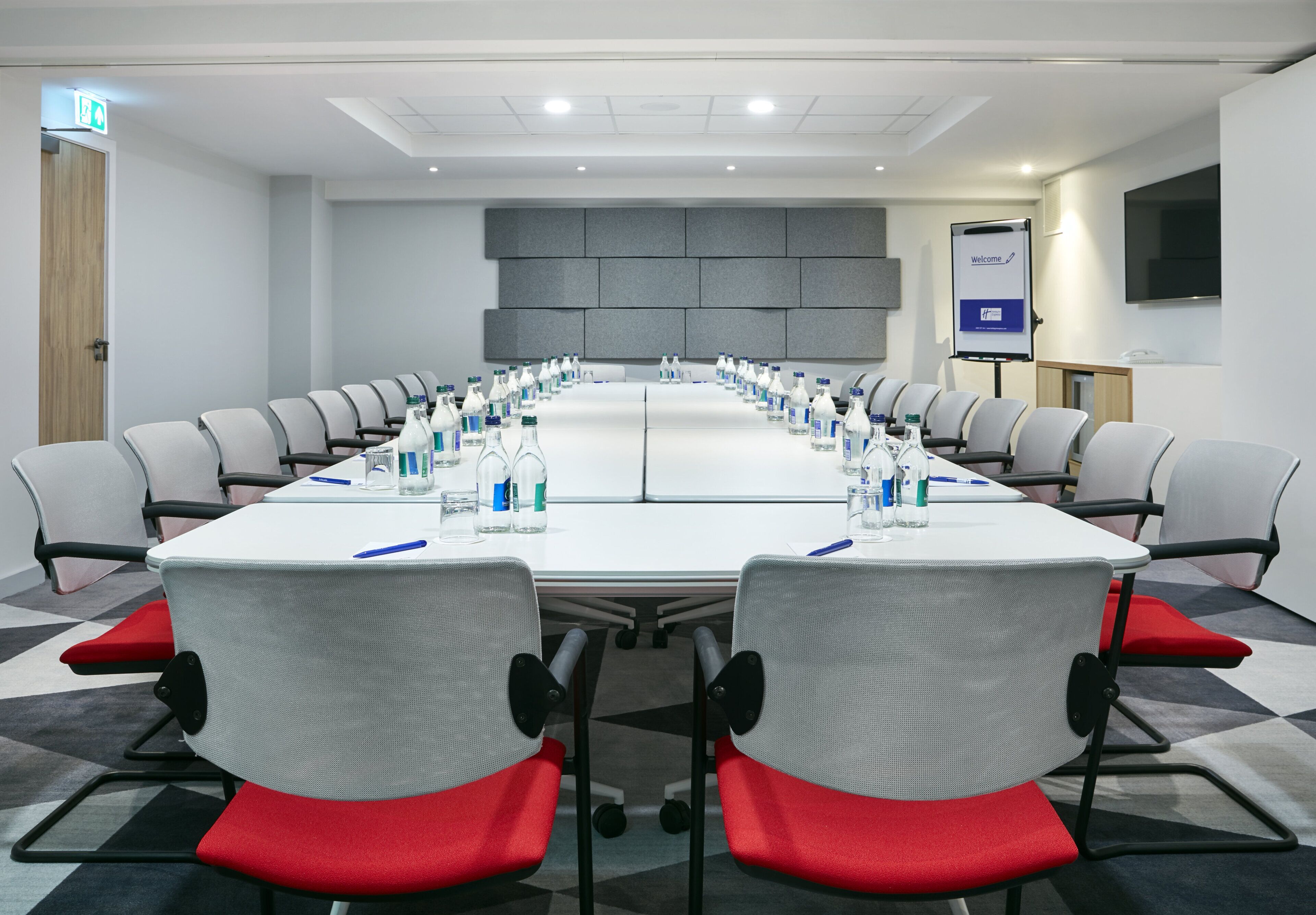 A conference room with a long table, chairs, and water bottles.