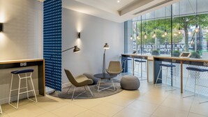 Ein moderner Empfangsbereich mit Bar, Sitzgelegenheiten und einem großen Fenster mit Blick auf die Stadt.