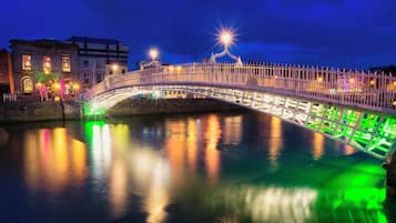 A bridge with a railing and lights, spanning over a body of water.