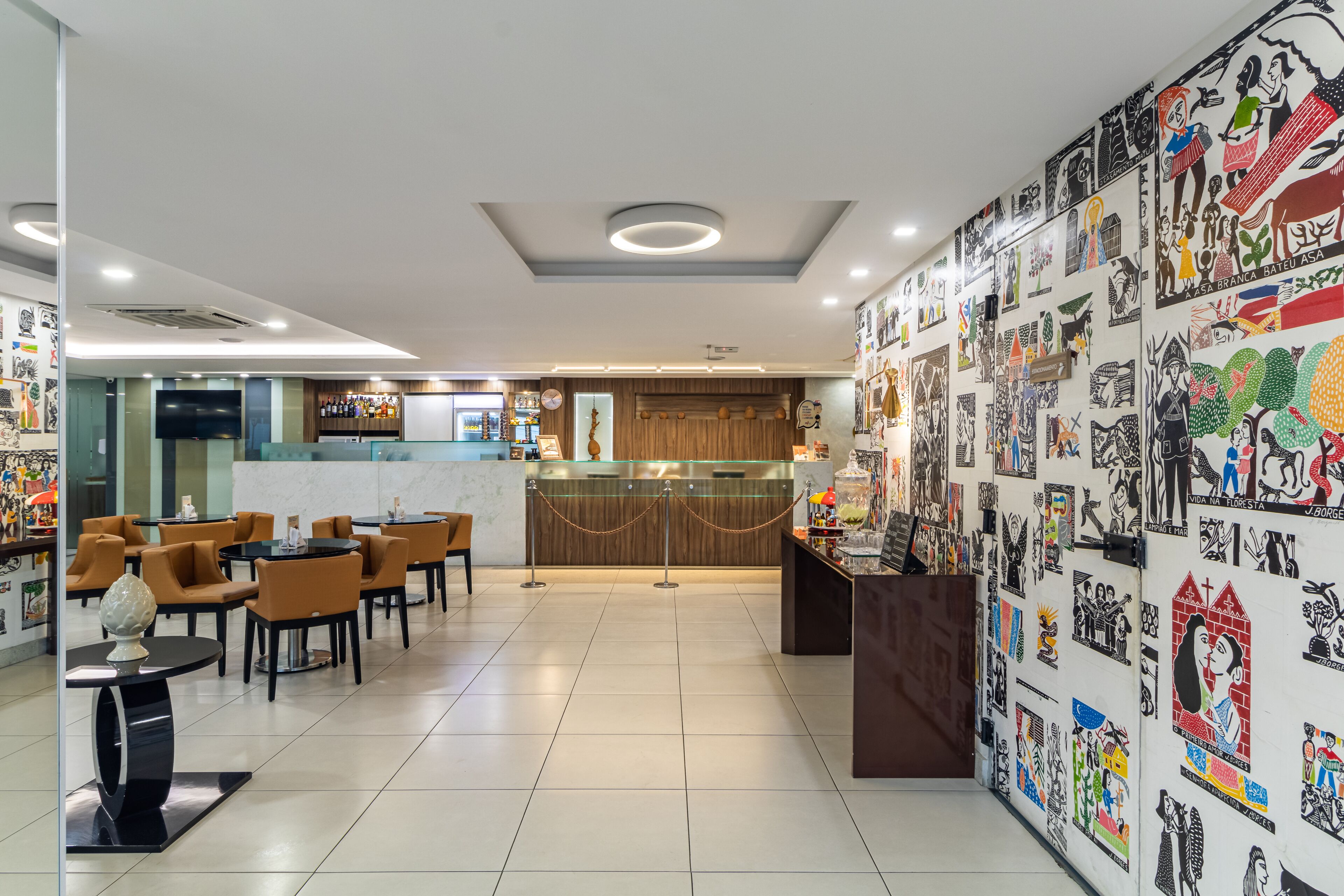 A modern restaurant with a bar area, wooden accents, and a wall decorated with various artworks.