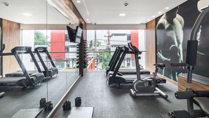 Un gimnasio con cintas de correr, elípticas y máquinas de pesas.