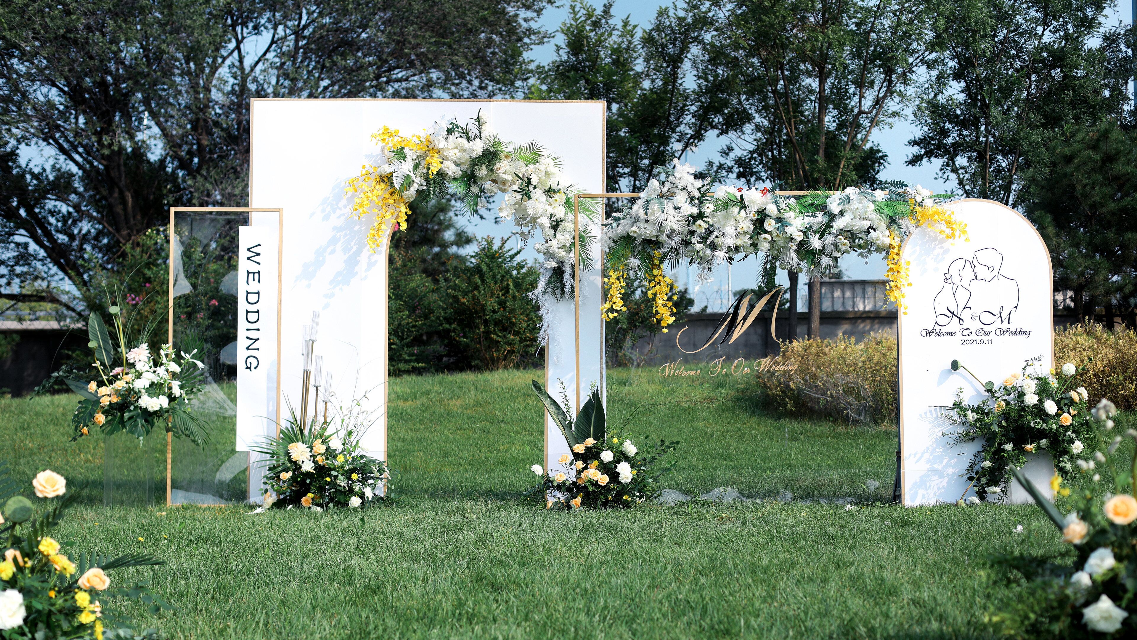 A wedding arch with floral decorations and a sign that reads "Welcome To Our Wedding 2021.9.11".