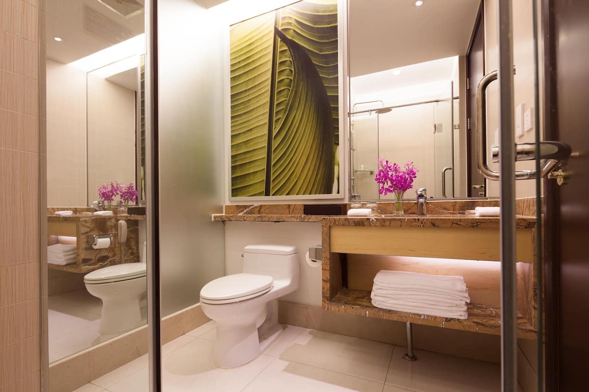 A modern bathroom with a toilet, sink, and shower.