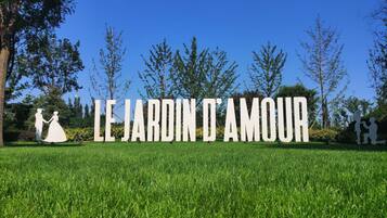 A sign with the text "LE JARDIN D'AMOUR" in a park setting.