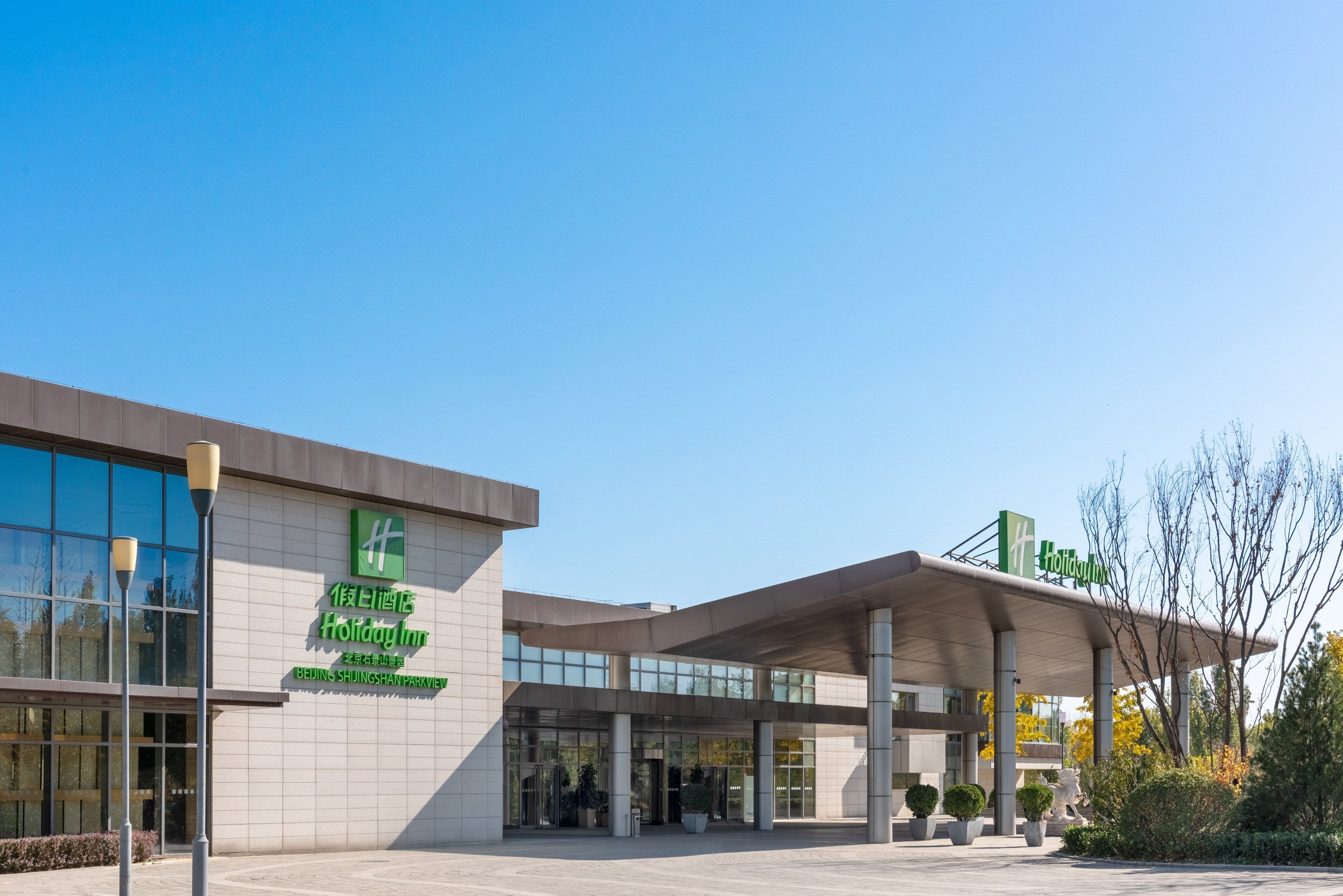 A Holiday Inn hotel with a modern design, featuring a large entrance and a covered outdoor area.