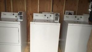 Kolme Whirlpool-merkkiä olevaa pesukonetta rivissä puista seinää vasten.