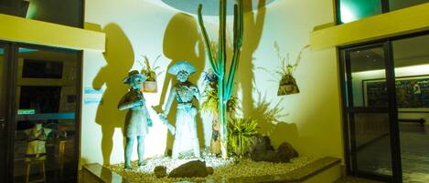A reception area with a central display of statues, a large window, and a modern interior design.