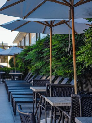 Outdoor seating with umbrellas and wicker furniture. - Safira Praia Hotel (Porto Seguro)