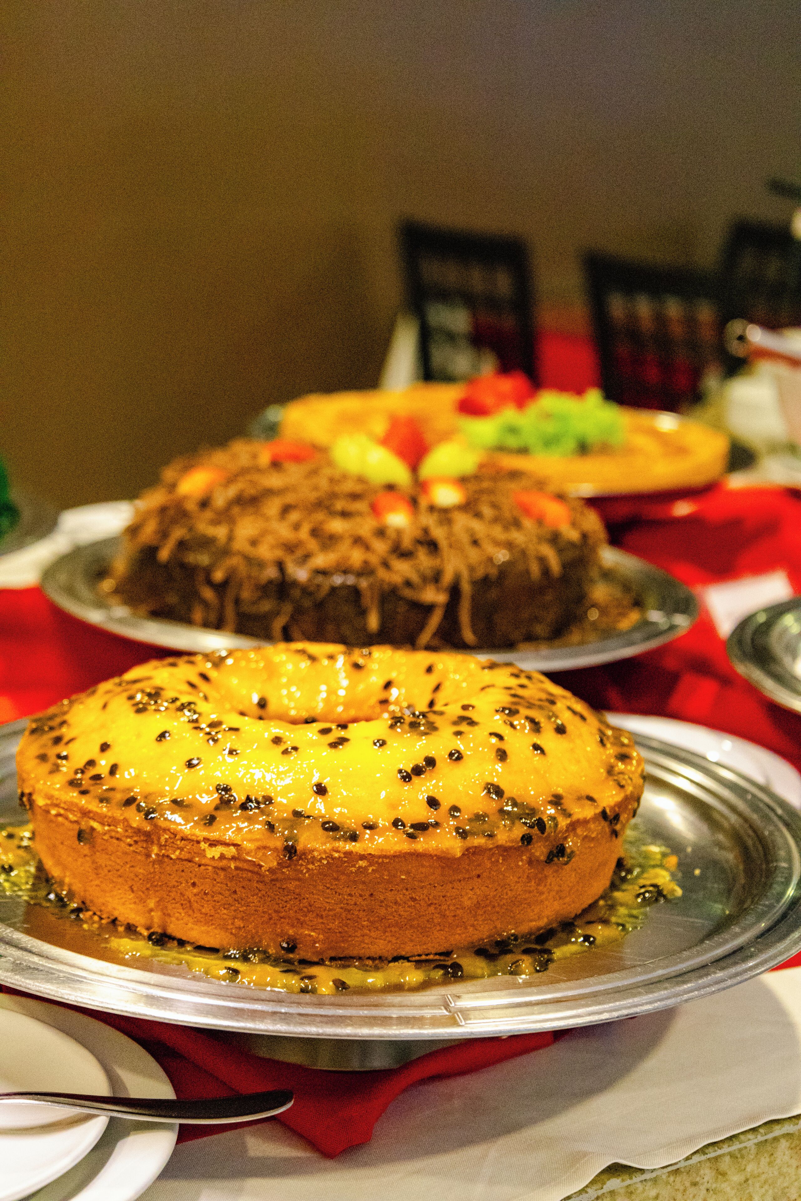 A table with various desserts, including a cake with black seeds on top.