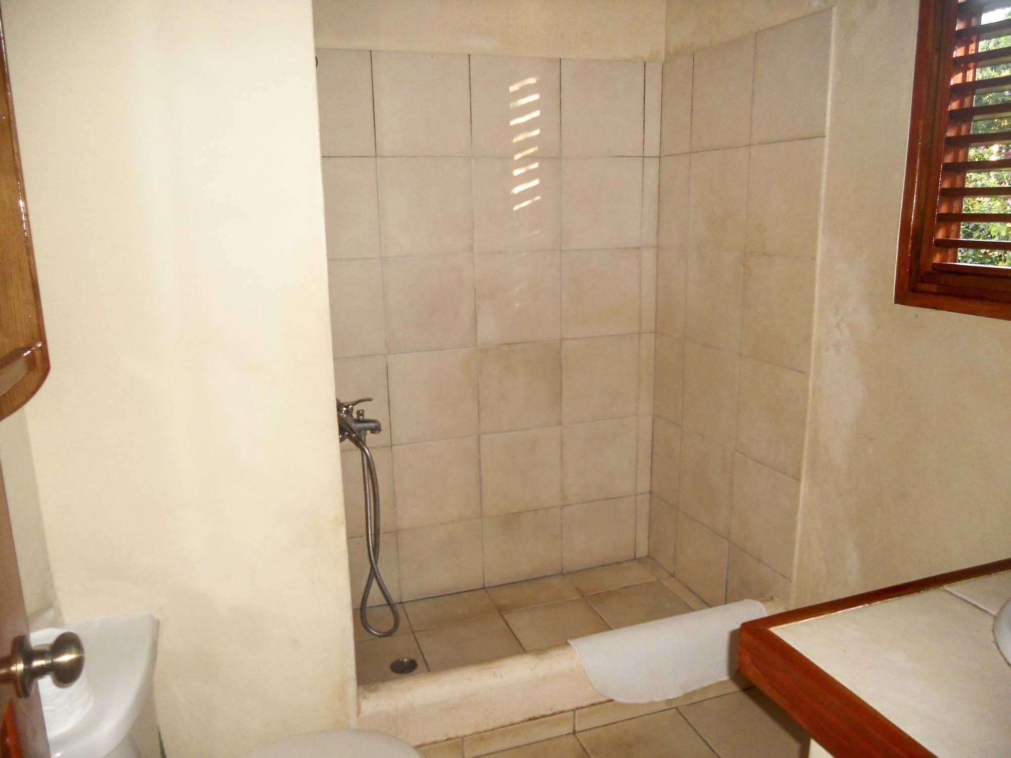 Ein kleines Badezimmer mit Dusche, Toilette und Waschbecken.