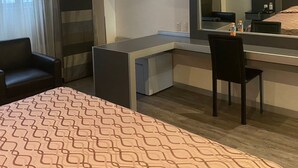 A hotel room with a bed, a desk, a chair, a television, and a ceiling fan. - Hotel Atenas Plaza (Mexico City)