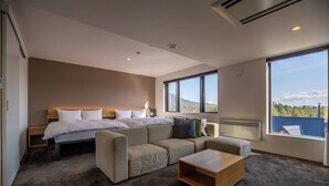 Un dormitorio moderno con una cama grande, un sofá, una mesa de centro y vistas al exterior.