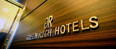 A sign with the text "Greenrich Hotels" on a wooden surface.