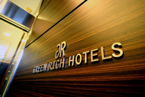A sign with the text "Greenrich Hotels" on a wooden surface. - Green Rich Hotel Hiroshima Shinkansenguchi (Artificial hot spring Futamata Yunohana) (Hiroshima)