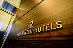 Un letrero con el texto 'Greenrich Hotels' sobre una superficie de madera.