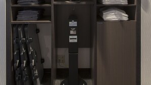 A storage closet with shelves for folded clothes, a shoe rack, and a black stand with a label. - Green Rich Hotel Hiroshima Shinkansenguchi (Artificial hot spring Futamata Yunohana) (Hiroshima)
