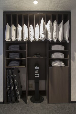 Un placard de rangement avec des étagères pour les vêtements pliés, un porte-chaussures et un présentoir noir avec une étiquette.