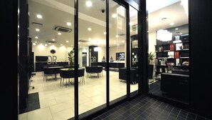 A modern interior with glass doors, a reception area, and a dining space.