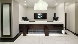 A modern bathroom with two sinks, a large mirror, and a 'DR' sign above the sinks.