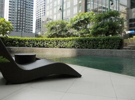Una piscina al aire libre, sillones reclinables de piscina