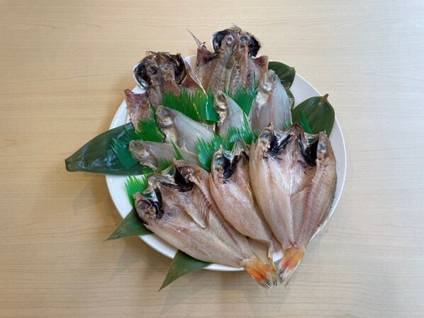 Un plato de pescado seco dispuesto sobre una mesa de madera.