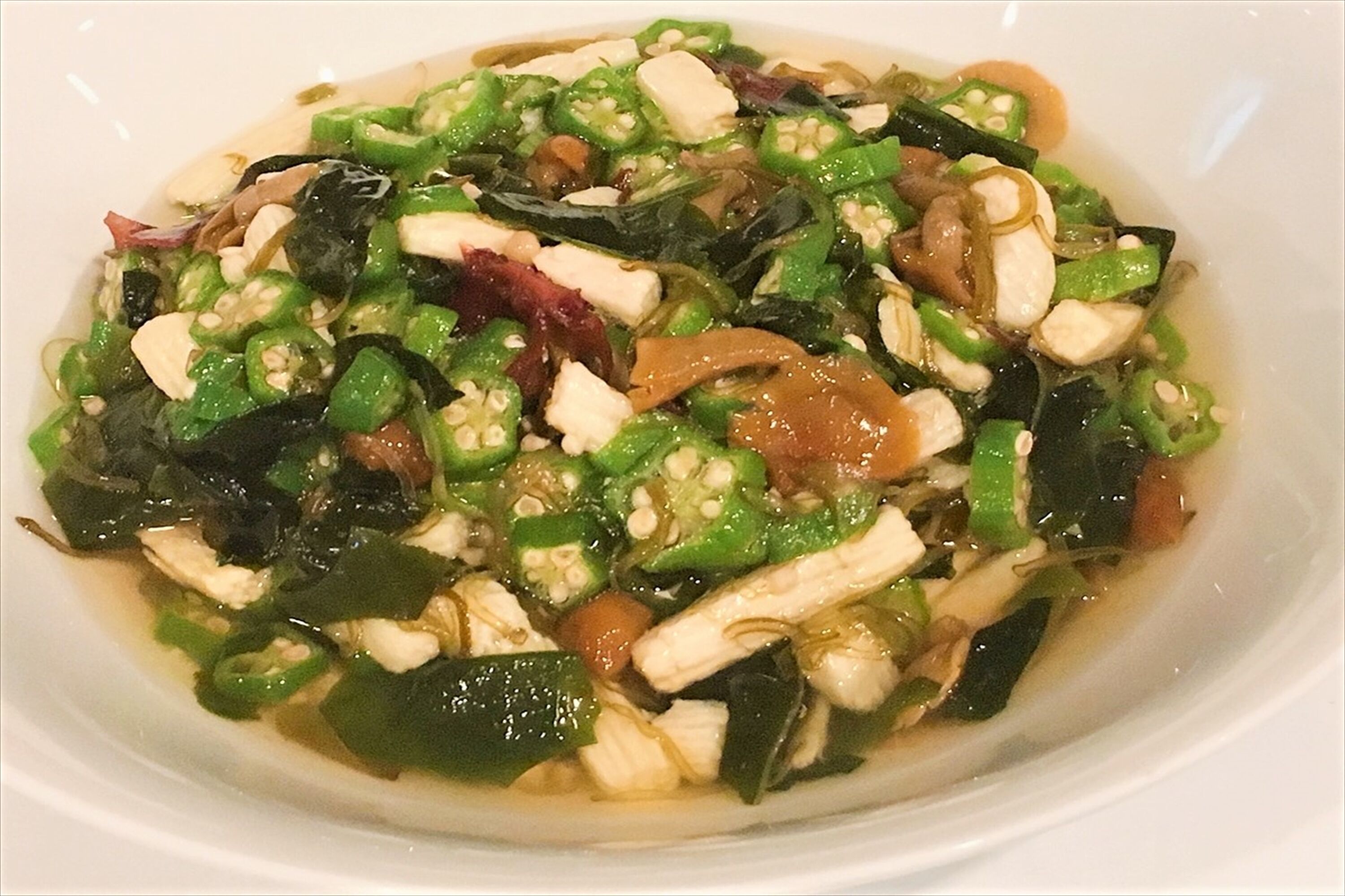 En skål med wokad grönsaksblandning med tofu och svamp.