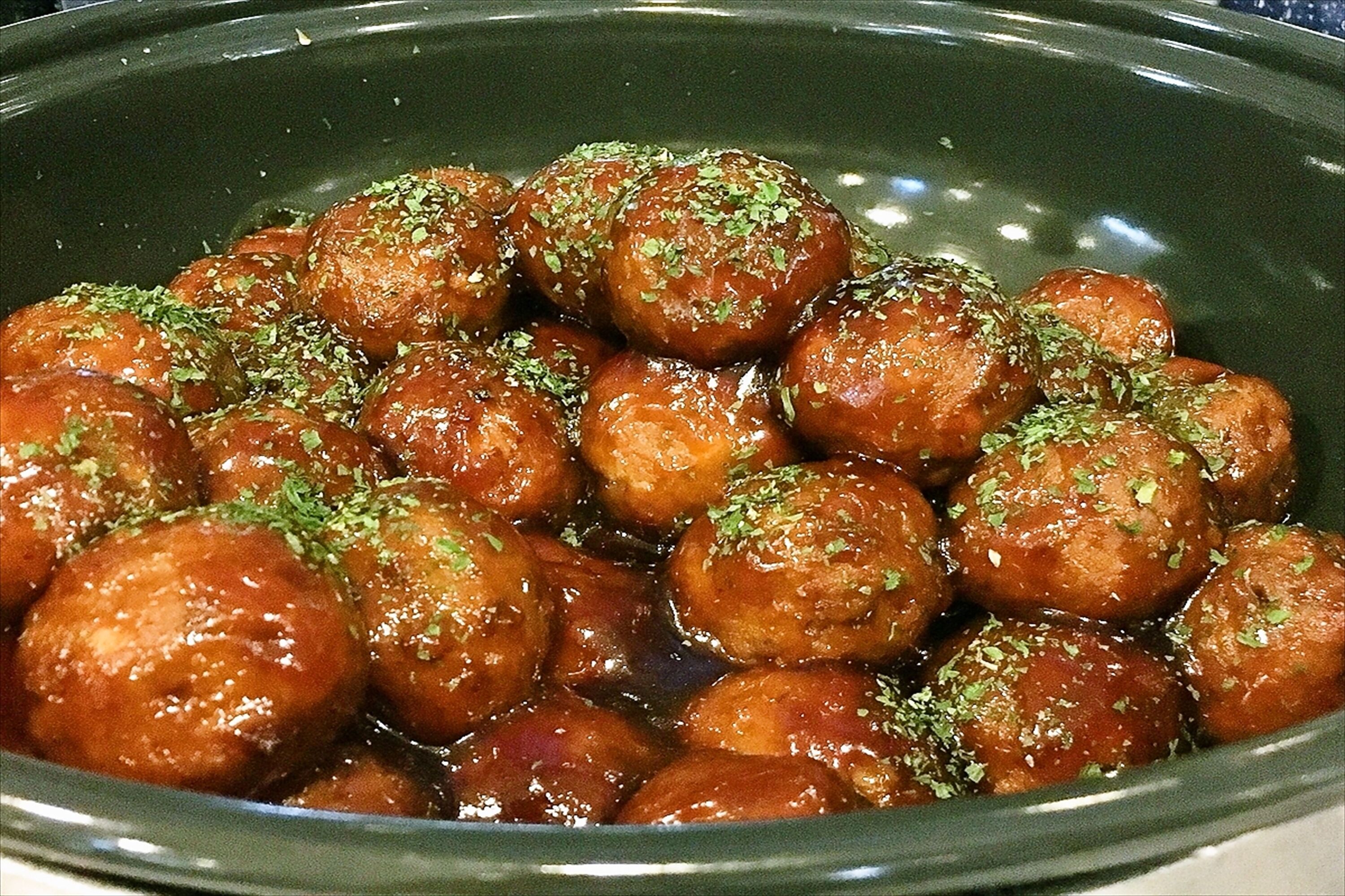 Un bol de bonbons ronds et glacés, décorés d’herbes aromatiques.