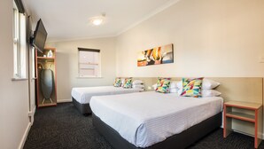 A hotel room with two beds, a flat-screen TV, a painting, and a small table. - Granville Hotel (Granville)