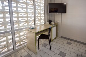 Minibar, escritorio, tabla de planchar con plancha y ropa de cama