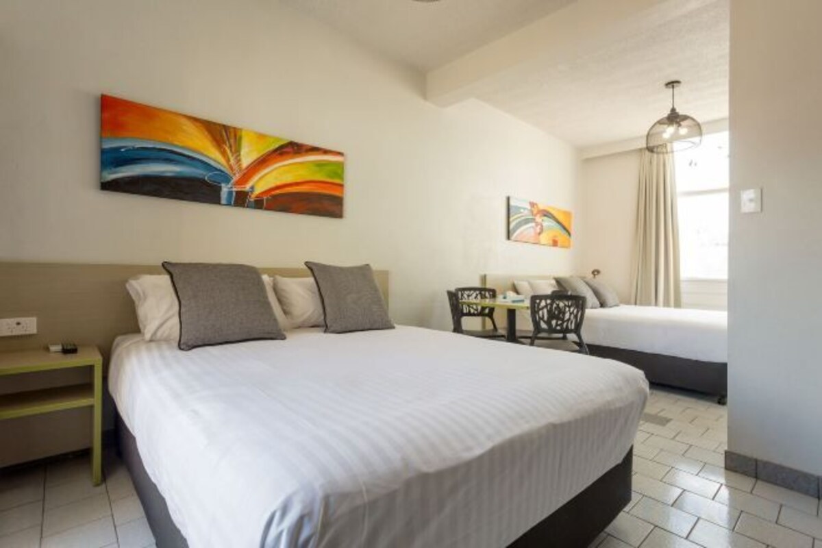 Minibar, escritorio, tabla de planchar con plancha y ropa de cama