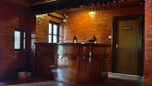 Eine Bar mit einer Holztresen, Ziegelwänden und einer Tür mit der Aufschrift 'CAURISHANNAAR'.